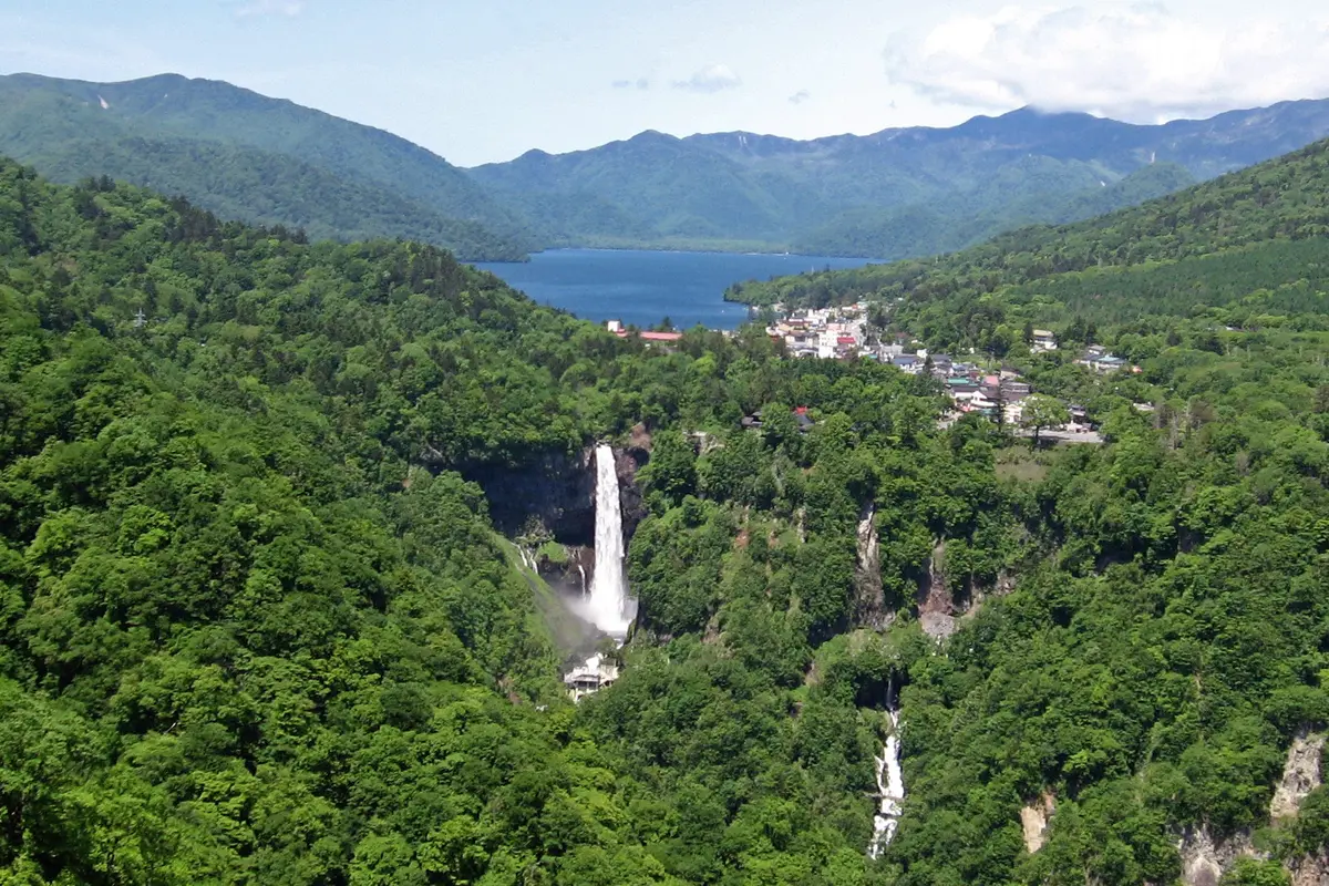 Les cascades de Kegon en una gorja boscosa sota el llac Chuzenji, amb la població de Chuzenji Onsen i les muntanyes al fons
